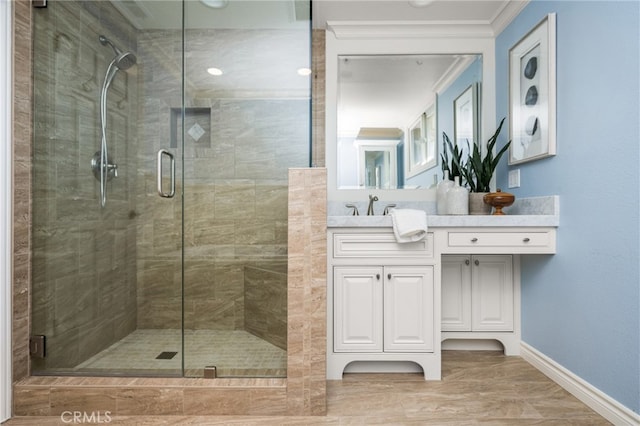 full bathroom with crown molding, baseboards, vanity, and a shower stall