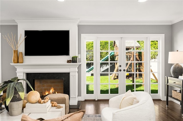 entryway with crown molding, a lit fireplace, dark wood-style floors, and french doors