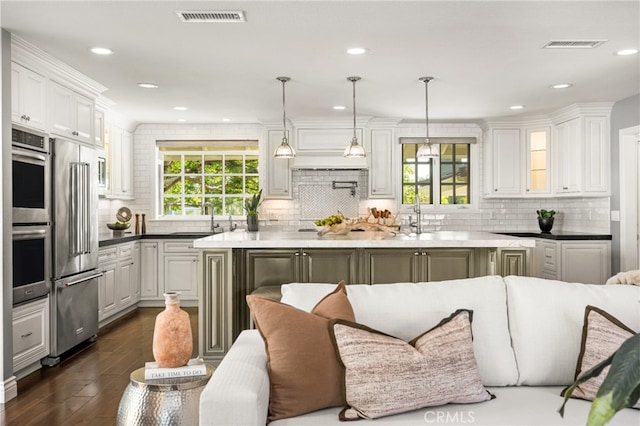 kitchen featuring visible vents, decorative backsplash, dark wood-style flooring, white cabinets, and appliances with stainless steel finishes