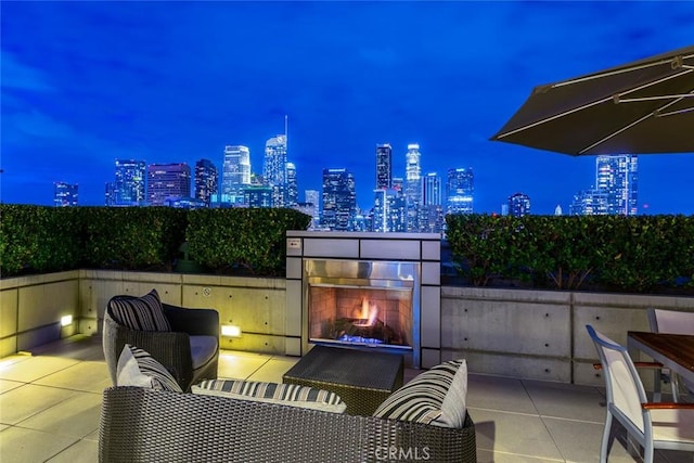 1155 S Grand Ave Unit 1011, Los Angeles, CA 90015 - patio at twilight with a lit fireplace, a view of city lights, and a patio area