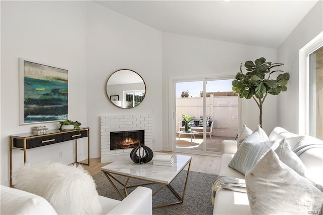 8892 Katella Ave Unit 12, Anaheim, CA 92804 - living room with high vaulted ceiling, wood finished floors, a brick fireplace, and baseboards