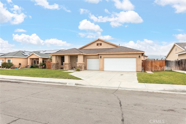 single story home featuring fence, stone siding, a garage, a front yard, and concrete driveway