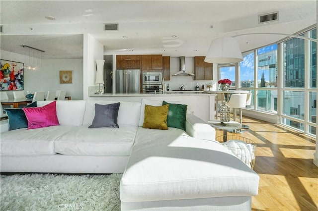 living area with light wood-style flooring and visible vents