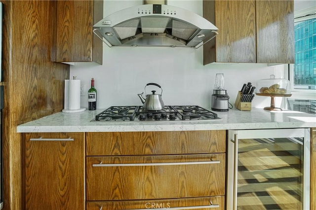 3141 Michelson Dr Unit 508, Irvine, CA 92612 - kitchen with island exhaust hood, beverage cooler, stainless steel gas cooktop, and brown cabinetry