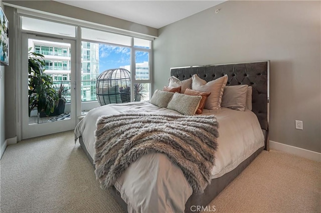 bedroom featuring baseboards, light carpet, and access to exterior