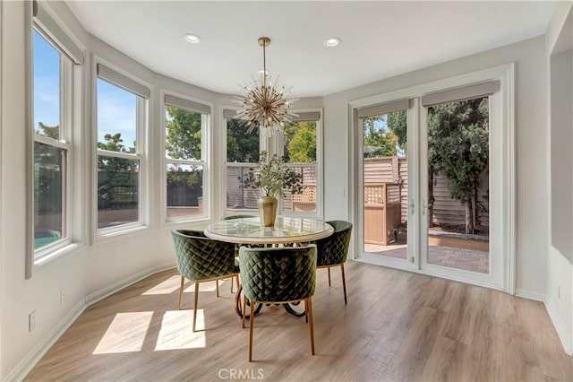 sunroom / solarium with an inviting chandelier, recessed lighting, baseboards, and wood finished floors