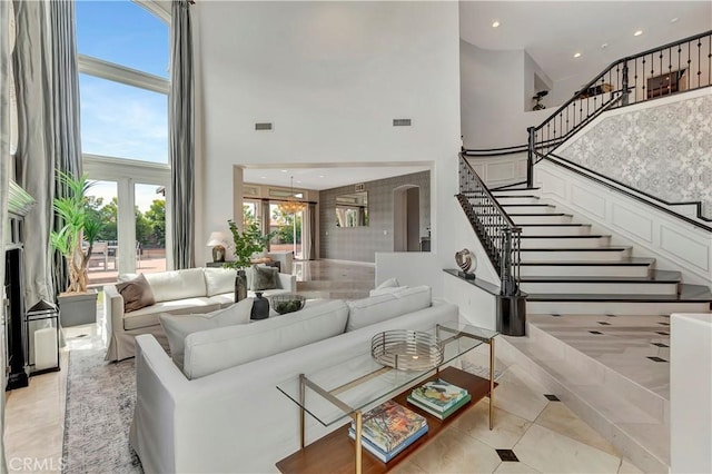 living area featuring light tile patterned flooring, a high ceiling, stairs, recessed lighting, and visible vents