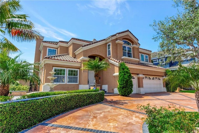 mediterranean / spanish-style house featuring a tiled roof, a garage, concrete driveway, and stucco siding