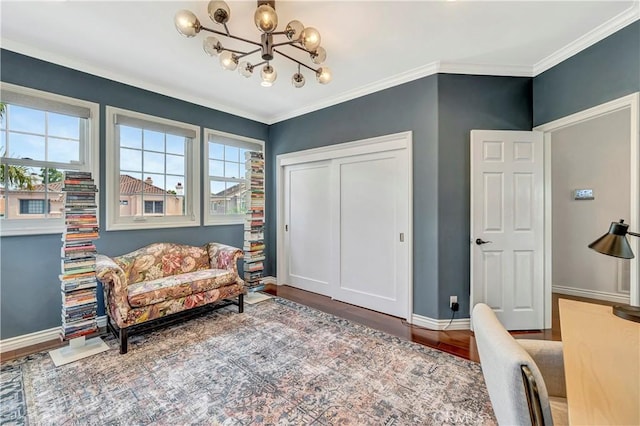 sitting room featuring baseboards, a chandelier, ornamental molding, and wood finished floors