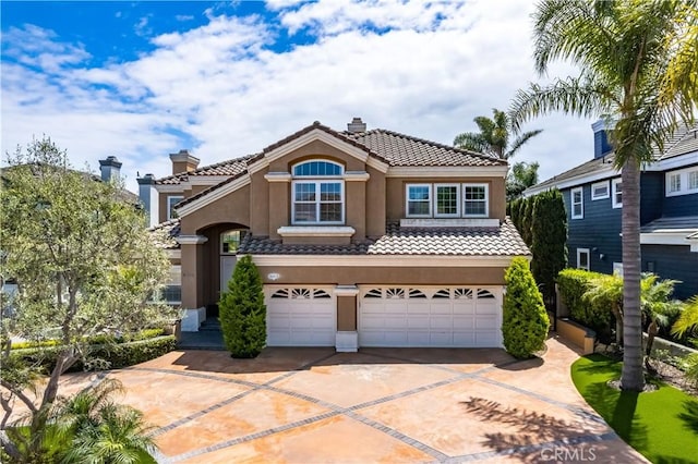 view of front facade with an attached garage, stucco siding, a chimney, concrete driveway, and a tiled roof