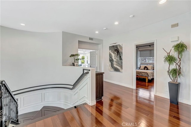 hallway featuring recessed lighting, wood finished floors, and visible vents