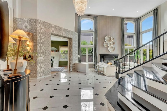 entrance foyer with stairs, a high ceiling, and a notable chandelier