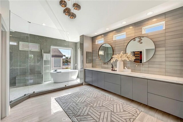 bathroom featuring recessed lighting, a freestanding bath, lofted ceiling, and vanity
