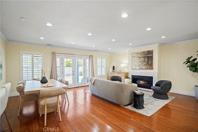 living room with crown molding, plenty of natural light, and french doors