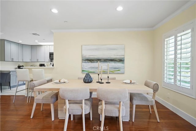dining area with crown molding, plenty of natural light, and wood finished floors