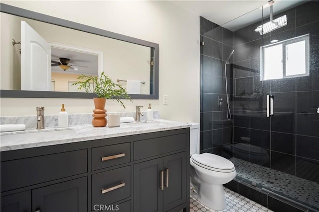 full bath with a ceiling fan, toilet, a shower stall, and a sink