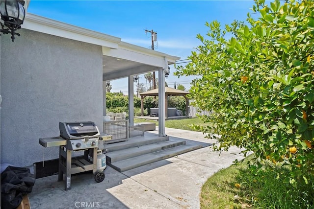view of patio with a gazebo, fence, and a grill