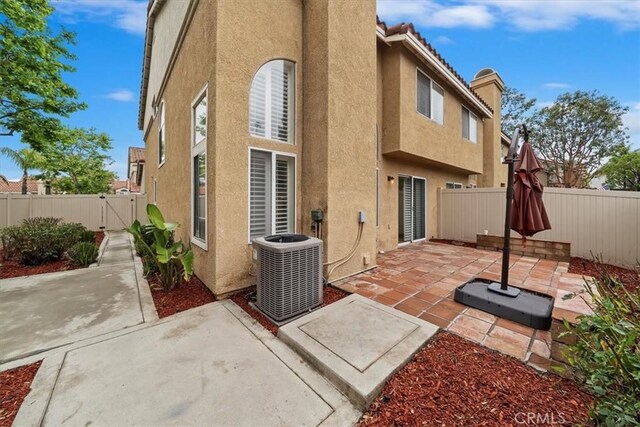 1101 Portofino Ct Unit 103, Corona, CA 92881 - back of house with central air condition unit, stucco siding, a fenced backyard, and a patio area