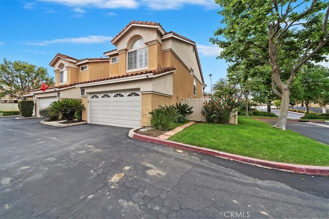 1101 Portofino Ct Unit 103, Corona, CA 92881 - mediterranean / spanish-style home with stucco siding, a tiled roof, an attached garage, and asphalt driveway