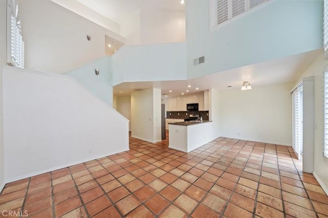 1101 Portofino Ct Unit 103, Corona, CA 92881 - unfurnished living room featuring a towering ceiling, stairway, recessed lighting, and baseboards