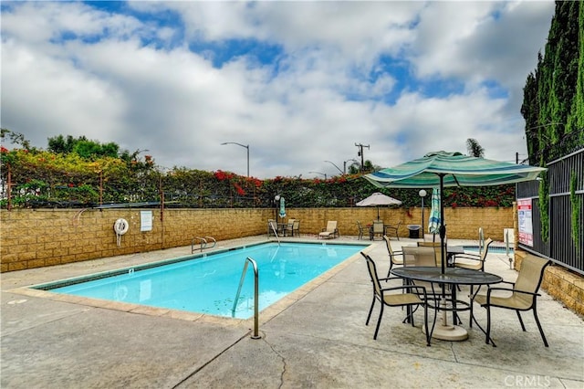 pool with fence and a patio area
