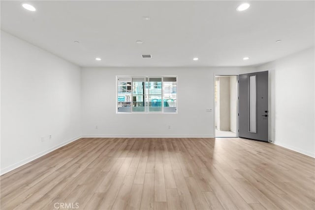 unfurnished living room with recessed lighting, light wood finished floors, baseboards, and visible vents