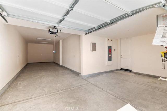 garage with baseboards, a garage door opener, and electric panel