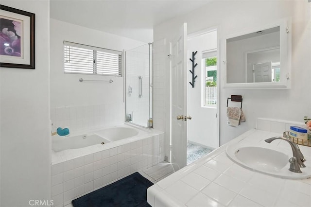 full bath with tiled shower, a healthy amount of sunlight, a sink, and a bath