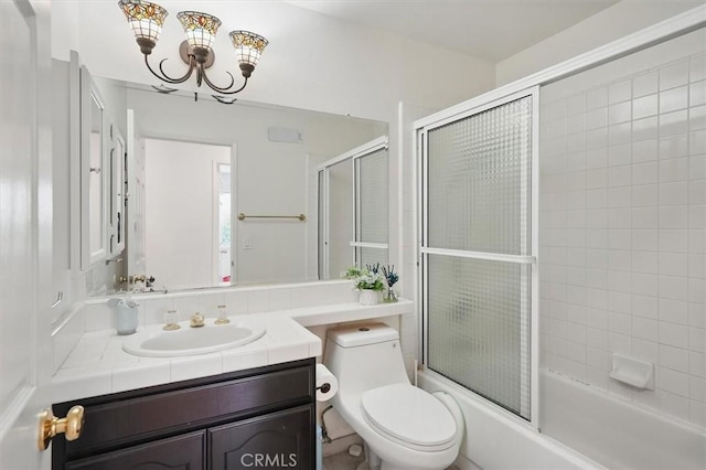 full bathroom featuring an inviting chandelier, shower / bath combination with glass door, toilet, and vanity