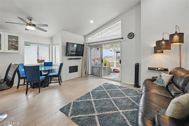 living area with a ceiling fan, baseboards, plenty of natural light, and wood finished floors