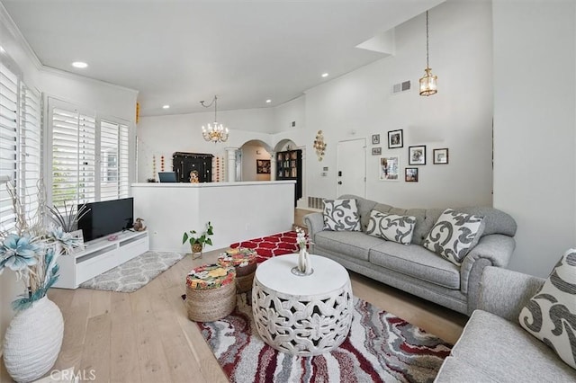 living area with visible vents, arched walkways, wood finished floors, a chandelier, and recessed lighting