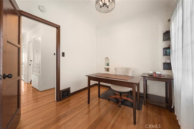 home office featuring light wood-style floors, baseboards, and visible vents