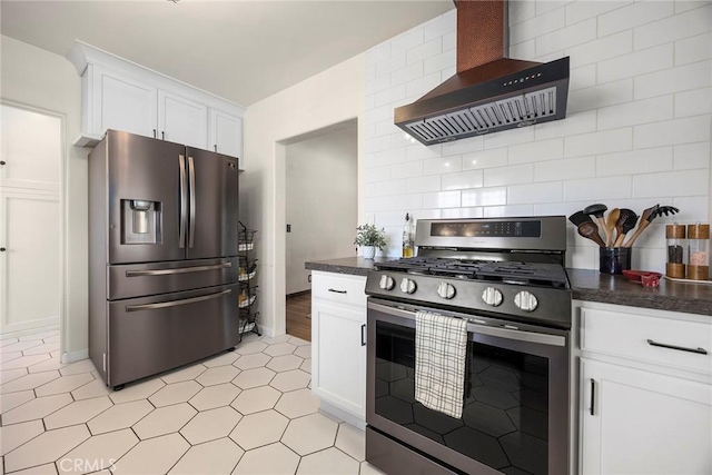 kitchen with wall chimney range hood, appliances with stainless steel finishes, dark countertops, baseboards, and white cabinets