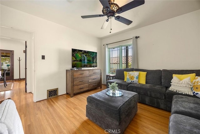 living area with ceiling fan, visible vents, a wealth of natural light, and light wood-type flooring
