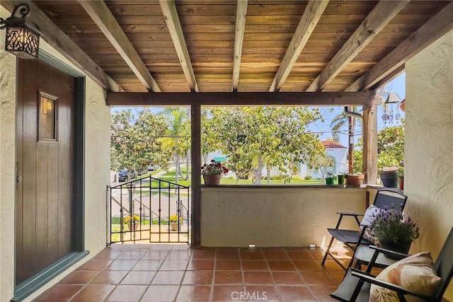 unfurnished sunroom featuring beamed ceiling