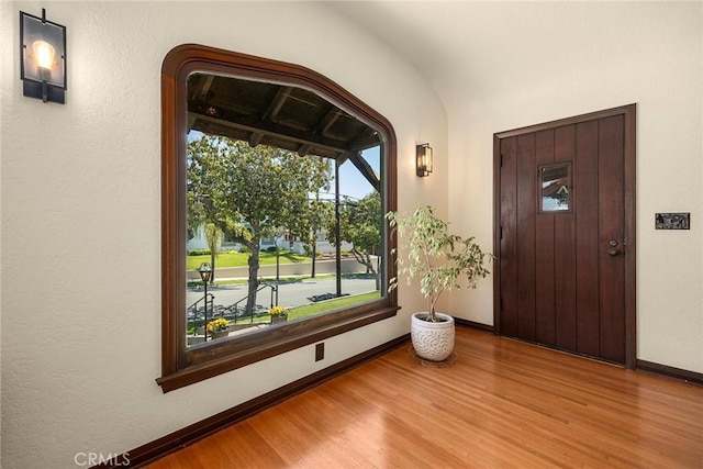 foyer entrance featuring baseboards and wood finished floors