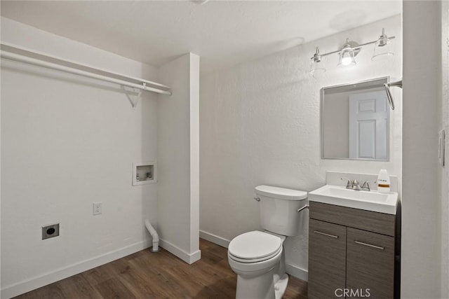 bathroom featuring vanity, baseboards, toilet, and wood finished floors