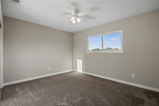 unfurnished room featuring baseboards, ceiling fan, dark colored carpet, and visible vents