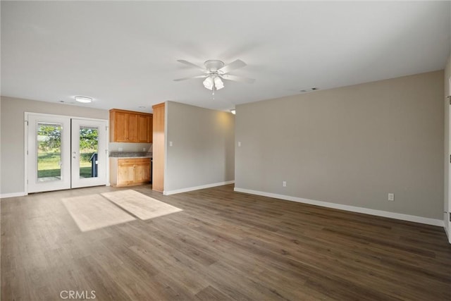 unfurnished living room featuring baseboards, ceiling fan, visible vents, and dark wood-type flooring