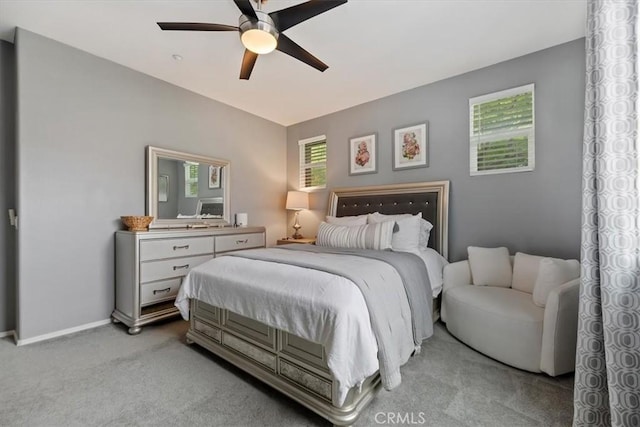 bedroom featuring ceiling fan, light colored carpet, and baseboards