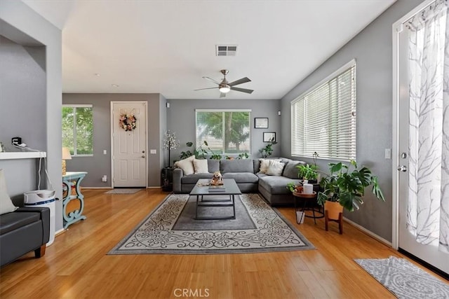 living area featuring ceiling fan, visible vents, plenty of natural light, and wood finished floors