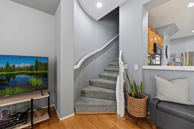 stairs with baseboards, recessed lighting, and wood finished floors