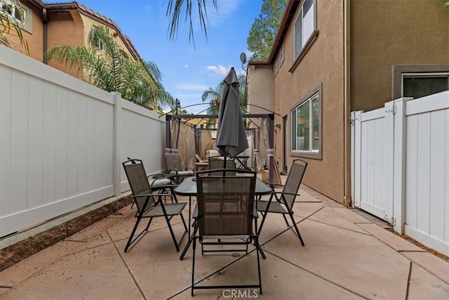view of patio / terrace with a fenced backyard, a gate, and outdoor dining space