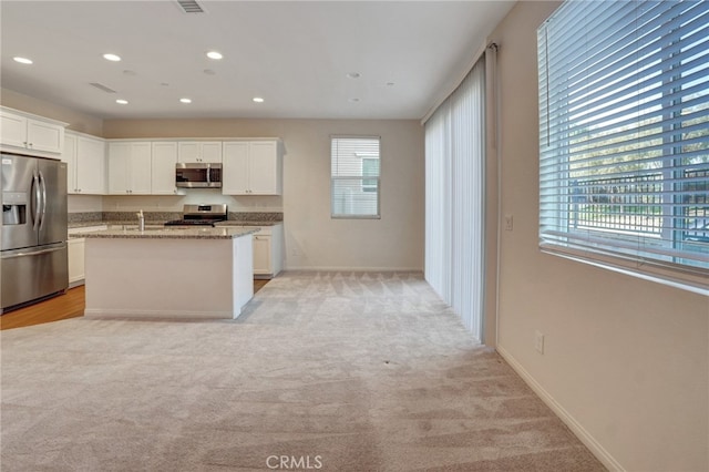 22824 W Olive Way, Canoga Park, CA 91304 - kitchen with light stone countertops, light carpet, white cabinets, a sink, and stainless steel appliances