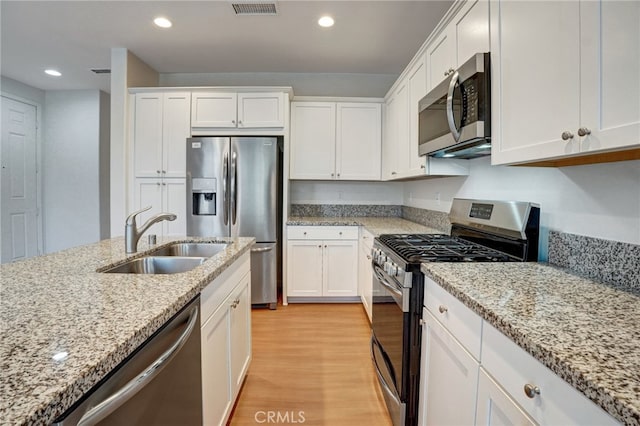 22824 W Olive Way, Canoga Park, CA 91304 - kitchen with light wood-type flooring, a sink, white cabinetry, and stainless steel appliances