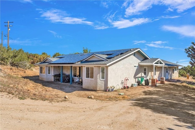 10634 Mesquite St, Oak Hills, CA 92344 - view of front facade featuring roof mounted solar panels and stucco siding
