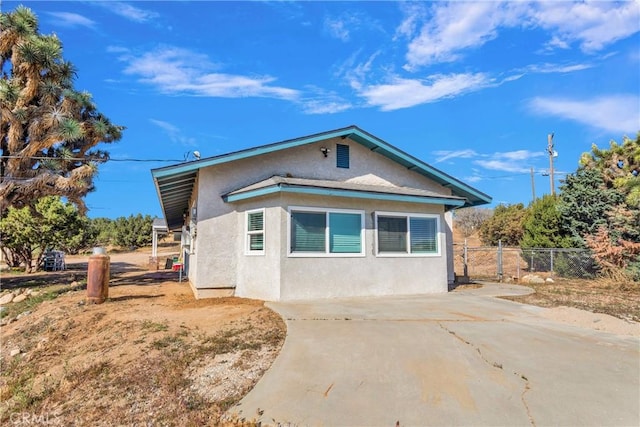 10634 Mesquite St, Oak Hills, CA 92344 - view of side of home featuring stucco siding and fence