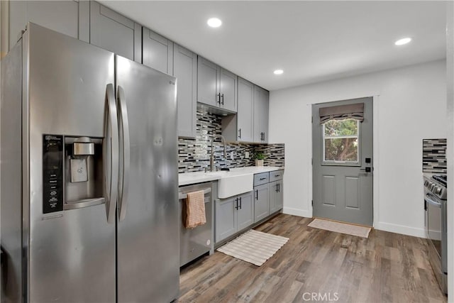 10634 Mesquite St, Oak Hills, CA 92344 - kitchen with decorative backsplash, a sink, light countertops, gray cabinetry, and stainless steel appliances