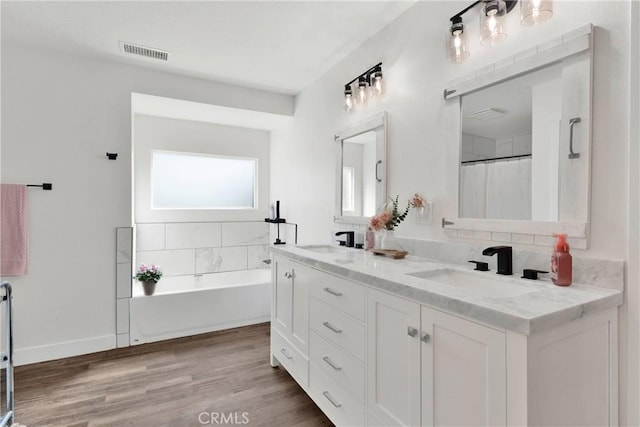10634 Mesquite St, Oak Hills, CA 92344 - bathroom featuring double vanity, visible vents, a sink, and a bath