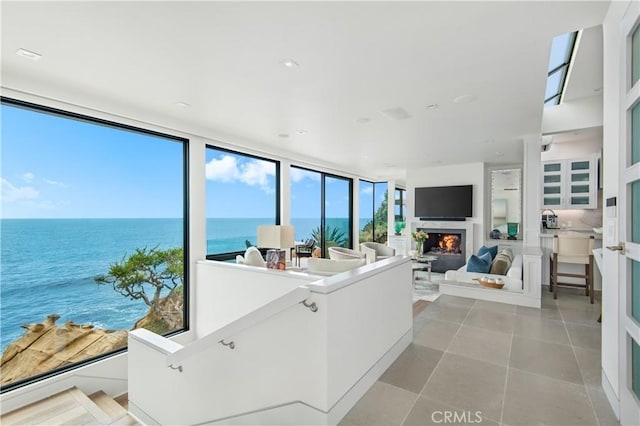 1715 Ocean Way, Laguna Beach, CA 92651 - living room featuring a warm lit fireplace, floor to ceiling windows, and light tile patterned flooring